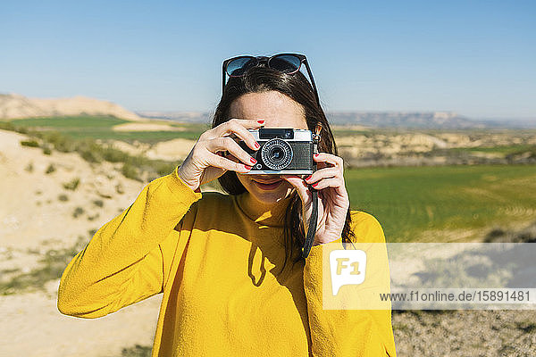 Woman taking pictures with a vintage camera  Bardenas Reales  Arguedas  Navarra  Spain