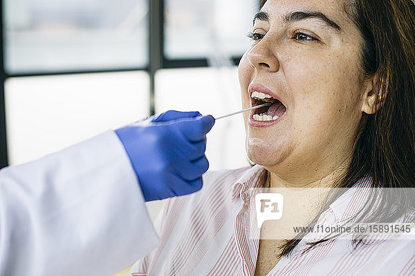 Nahaufnahme einer Abstrichentnahme aus dem Mund des Patienten