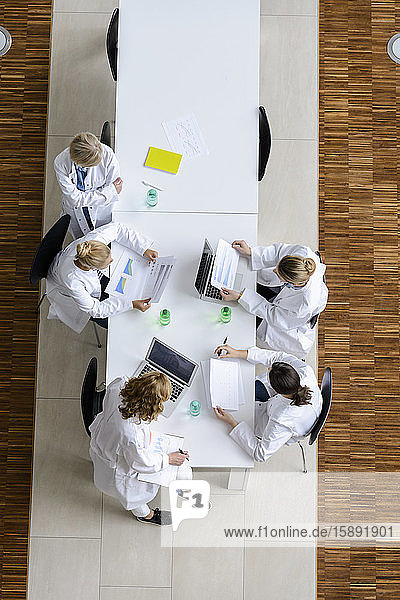 Ärztinnen beim Lesen von Vorträgen in einer Sitzung im Konferenzraum