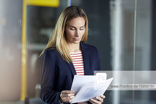 Porträt einer Geschäftsfrau  die im Amt Papiere überprüft