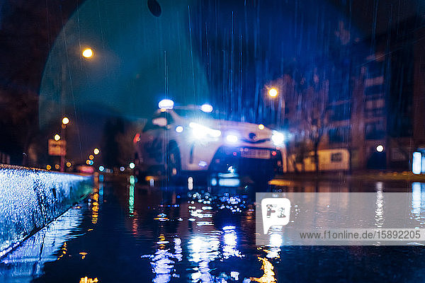 Spanien  Madrid  Oberflächenansicht eines Polizeiautos  das mitten in der regnerischen Nacht fährt
