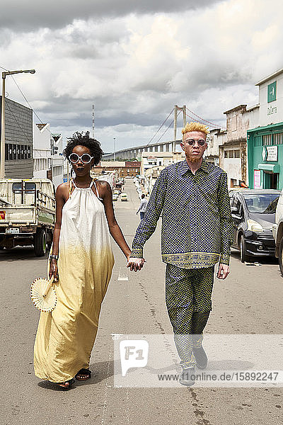 Porträt eines modischen Paares  das Hand in Hand auf der Straße geht  Maputo  Mosambik