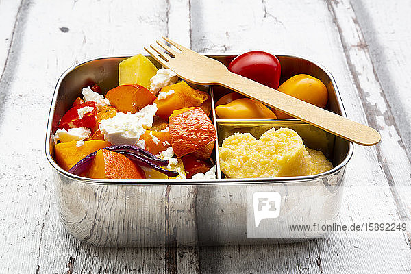 Lunchbox mit im Herbst im Ofen gebackenem Gemüse  Fetakäse und herzförmiger Polenta