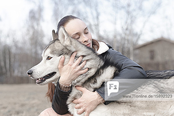 Glückliche Frau kuschelt mit ihrem Hund