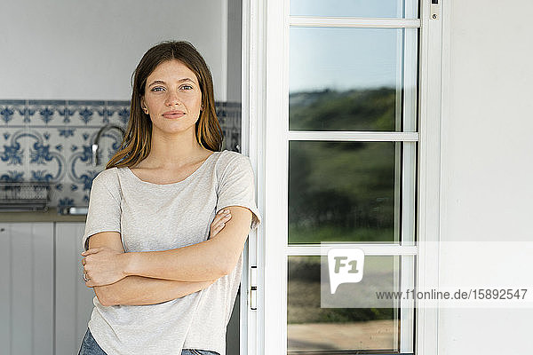 Porträt einer attraktiven jungen Frau  die zu Hause in der Tür steht