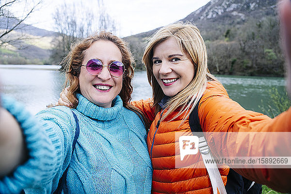 Porträt von zwei glücklichen Frauen  die Selbstsucht nehmen  Stausee Valdemurio  Asturien  Spanien