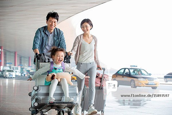 Happy family pushing baggage at the airport