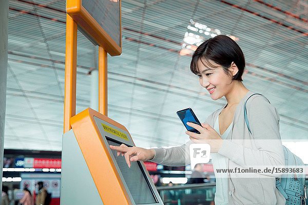 Business lady in the airport to use automatic machines