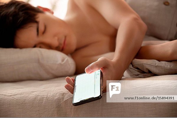 Young men play to mobile phone fell asleep