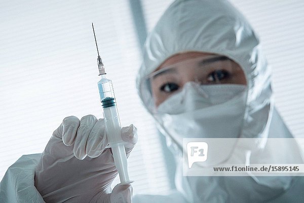 Wear protective clothing a doctor with a syringe