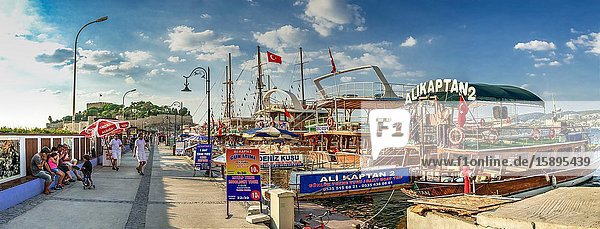 Kusadasi Turkey â. “ 07. 18. 2019. Pleasure boat parking near Kusadasi castle in Turkey on a summer evening.