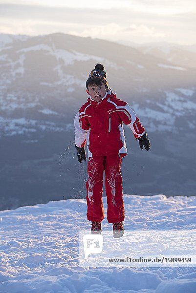 Boy jumping in winter on sunset.