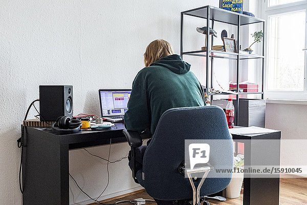 Berlin Netherlands. Young Bimm Academy Student producing his urban music inside his small Friedrichshain apartment while being in self quarantine due to Corona.