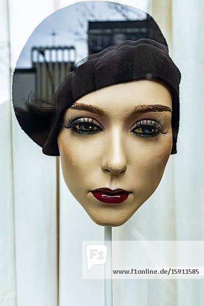 Berlin Germany. An Artificual Mannequin Head with head on display inside a shop's and fashion store window reflecting a church inside her head.