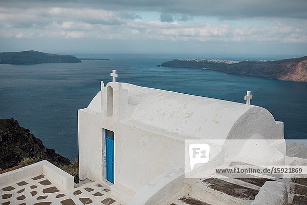 Views from Imerovigli with a church the Aegean Sea and Oia in Santorini Greece.