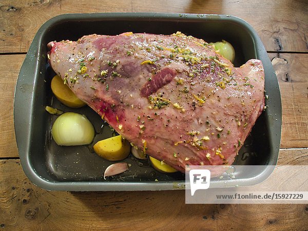 Leg of lamb with potatoes and onions ready for roasting Lauzun Lot-et-Garonne Department Nouvelle Aquitaine France.