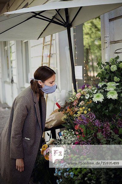 Woman with mask buying flowers.