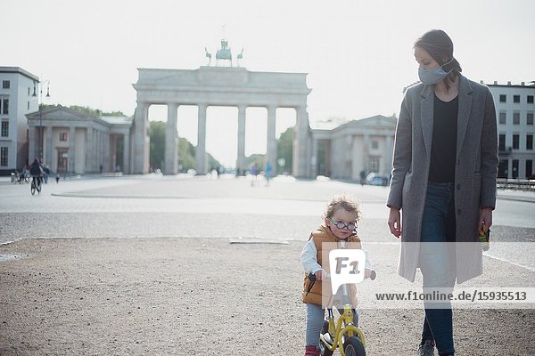Mother and son walking with mask in Berlin in an empty Brandenburg gate during Corona time.