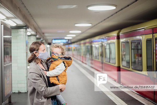 Mother and son taking public transportation with mask during Corona days.