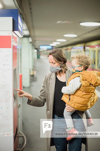 Mother and son taking public transportation with mask during Corona days.