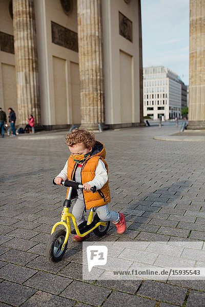 Little boy 2-3 years old with mask and bicycle in Berlin.