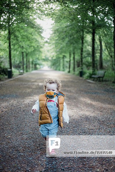 Little boy 2-3 Years old wih mask in the park.