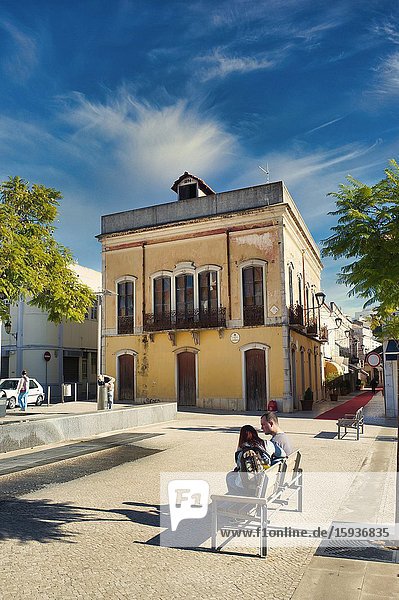 Couple on a park bench Largo de Sao Francisco Loule Algarve Portugal.
