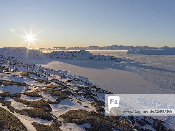 Sunrise during winter at the Ilulissat Icefjord located in the Disko Bay in West Greenland the Icefjord is part of the UNESCO world heritage. America North America Greenland Denmark.