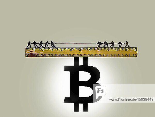 Tauziehen auf einem Lineal  das auf einem Bitcoin-Zeichen balanciert