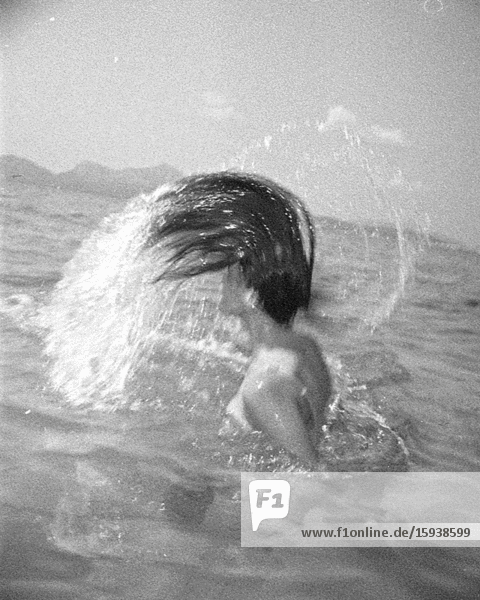Frau,  die ihr langes nasses Haar am Strand auswirft,  3D-Stereo-Effekt