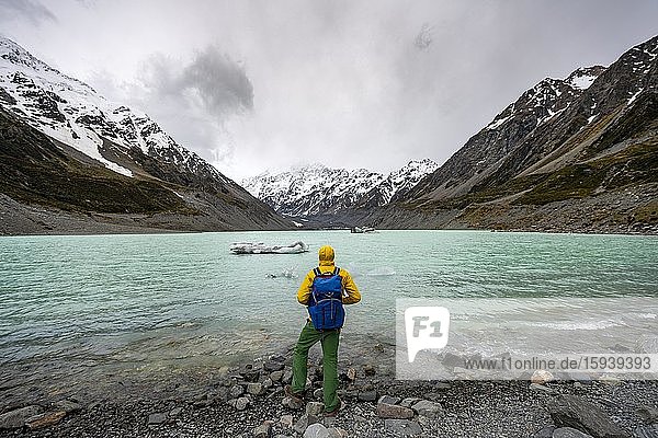 Hiker views Hooker Lake in Hooker Valley  Mount Cook National Park  Southern Alps  Hooker Valley  Canterbury  South Island