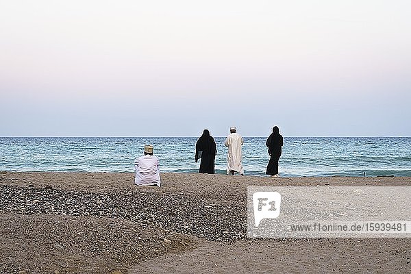 Omanische Männer und Frauen in traditioneller Kleidung am Strand  Qantab  Oman  Asien