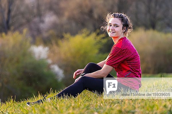 Woman  23 years old  sitting relaxed on the meadow  Germany  Europe
