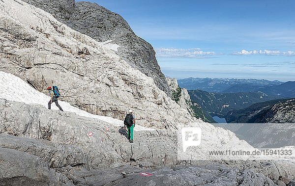 Bergsteigerinnen auf markierter Route durch felsiges alpines Gelände  von Simonyhütte zur Adamekhütte  hinten Ausblick auf Gossausee  Salzkammergut  Oberösterreich  Österreich  Europa