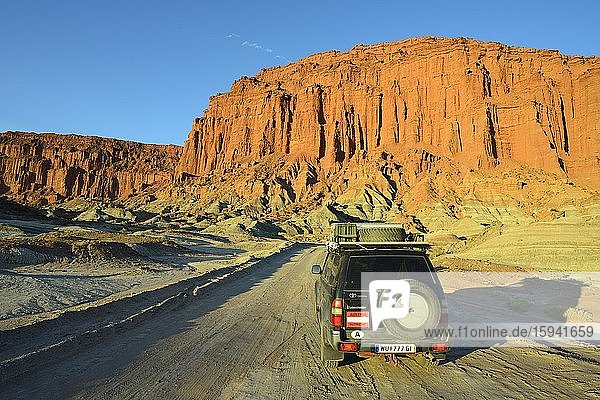 Off-road vehicle  Toyota Land Cruiser on the road in front of a red rock face  Ischigualasto Nature Reserve  San Juan Province  Argentina  South America