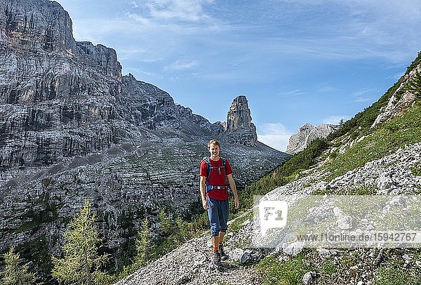 Junger Wanderer auf dem Wanderweg Sentiero Carlo Minazio  hinten Bergspitze des Torre dei Sabbioni  Sorapiss Umrundung  Dolomiten  Belluno  Italien  Europa