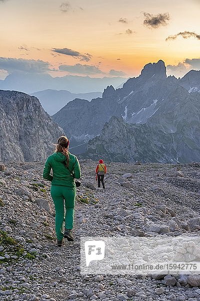 Zwei Wanderer in felsigem alpinen Gelände  Sonnenuntergang über Gosaukamm mit Berggipfel Bischofsmütze  Abendstimmung  Salzkammergut  Oberösterreich  Österreich  Europa