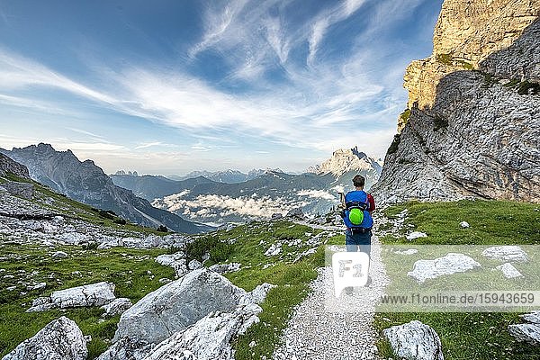 Hiker  mountaineer on a trail between rocky mountains at Forcella Grande  behind Monte Pelmo  Sorapiss circuit  Dolomites  Belluno  Italy  Europe