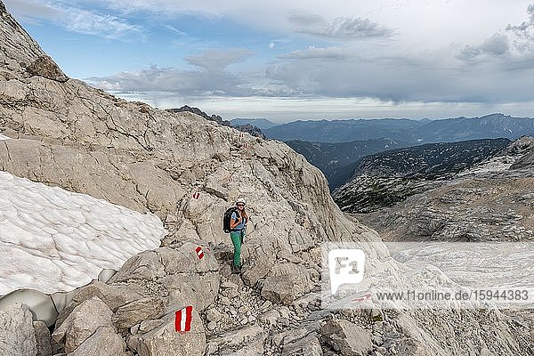 Bergsteigerin auf markierter Route durch felsiges alpines Gelände  von Simonyhütte zur Adamekhütte  Salzkammergut  Oberösterreich  Österreich  Europa