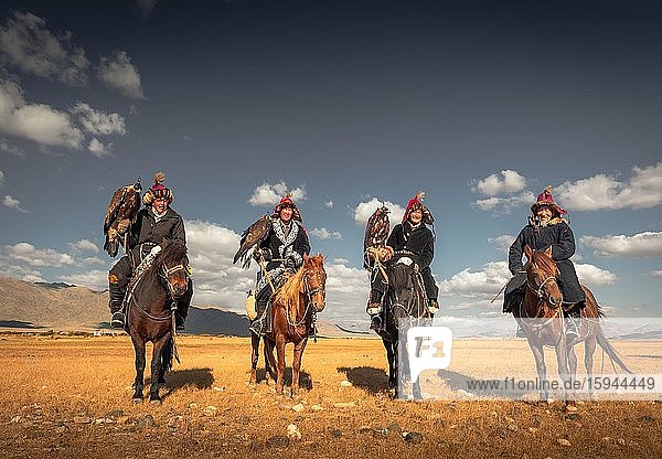 Mongolian eagle hunters  four Kazakhs with trained eagles on horses in the Mongolian steppe  Bayan-Ölgii Province  Mongolia  Asia