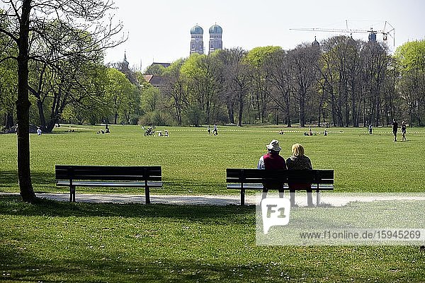 Paar sitzt auf einer Bank im Englischen Garten  Coronakrise München  Oberbayern  Bayern  Deutschland  Europa