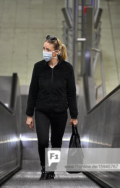 Frau mit Atemschutzmaske  fährt Rolltreppe  Corona-Krise  Stuttgart  Baden-Württemberg  Deutschland  Europa
