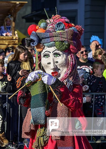 Maskierte Person  strickende Frau  Fasnachtsumzug der Wey-Zunft am Rosenmontag  Güdismäntig  Luzerner Fasnacht 2020  Luzern  Schweiz  Europa