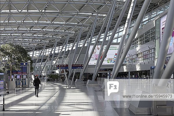 Einzelne Person geht durch die Abflughalle  Flughafen Düsseldorf während der Corona-Pandemie  Nordrhein-Westfalen  Deutschland  Europa