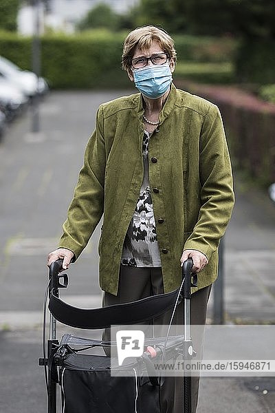 Seniorin mit Mund- und Nasenschutz und Rollator auf der Straße  während Corona Pandemie  Nordrhein-Westfalen  Deutschland  Europa