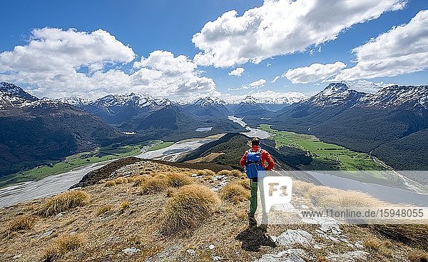 Wanderer auf dem Berggipfel von Mount Alfred  Ausblick in das Tal des Dart River  schneebedeckte Gipfel der Neuseeländischen Alpen  Glenorchy bei Queenstown  Südliche Alpen  Otago  Südinsel  Neuseeland  Ozeanien