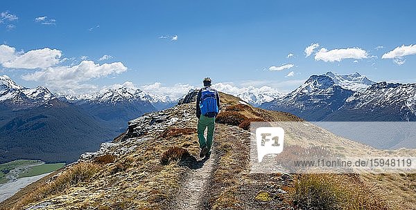 Hiker on the summit of Mount Alfred  view of snow-capped peaks of the New Zealand Alps  Glenorchy near Queenstown  Southern Alps  Otago  South Island  New Zealand  Oceania