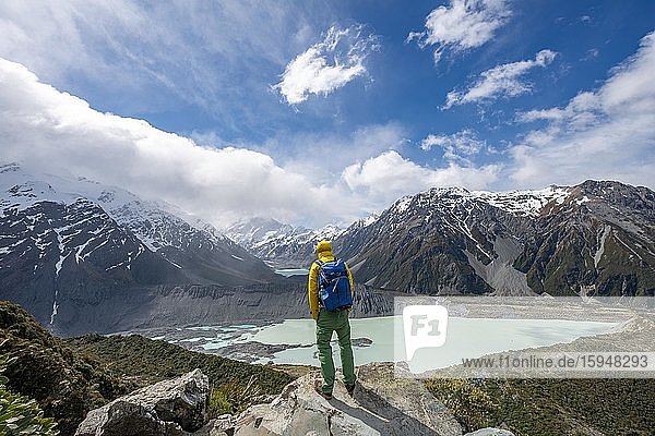 Hiker stands on rocks  views of the Hooker Valley from the Sealy Tarns Track  glacial lakes Mueller Lake and Hooker Lake  Mount Cook National Park  Canterbury Region  South Island  New Zealand  Oceania
