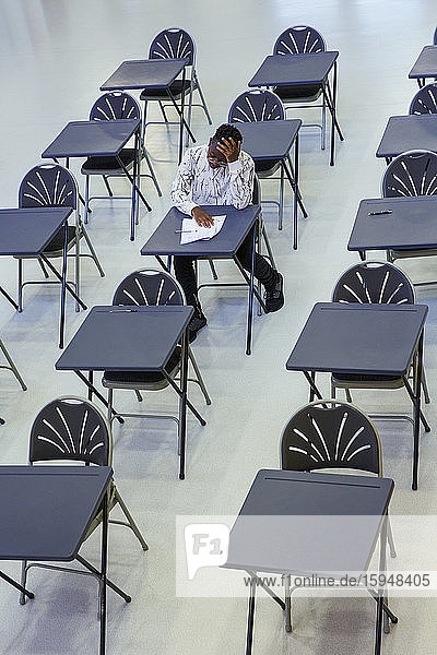 Engagierter High-School-Schüler nimmt Prüfung am Schreibtisch im Klassenzimmer ab