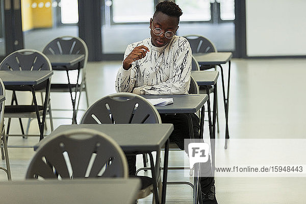 High-School-Schüler nimmt Prüfung am Schreibtisch im Klassenzimmer ab